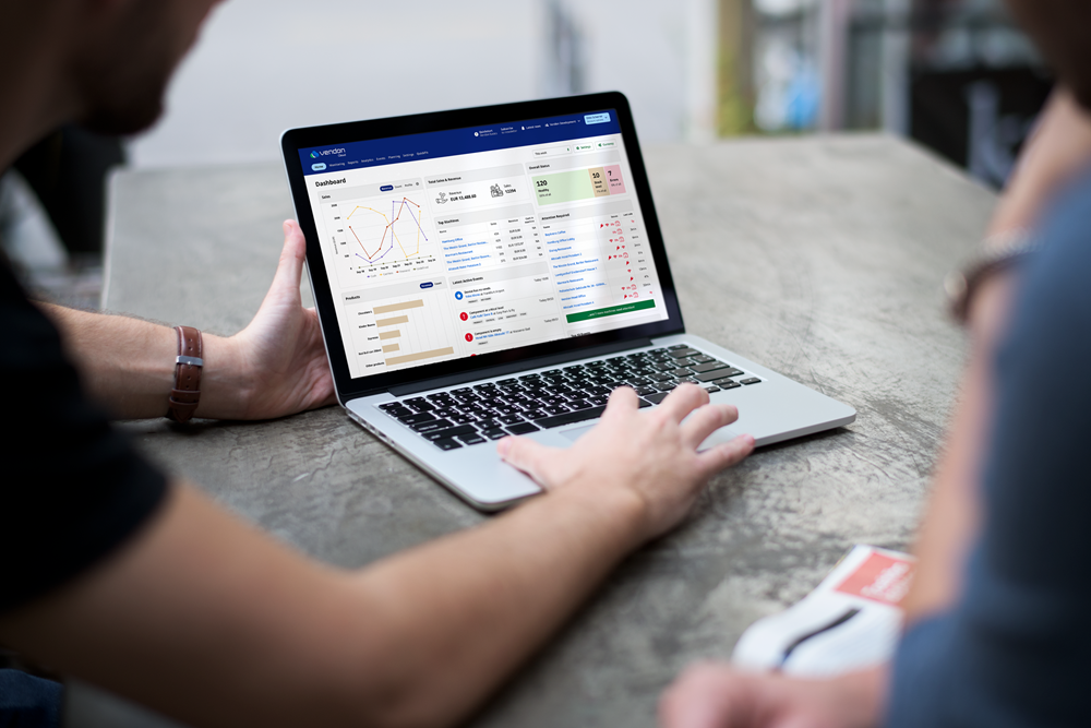 Mann analysiert Verkaufsdaten auf Laptop-Dashboard für Automatenmanagement