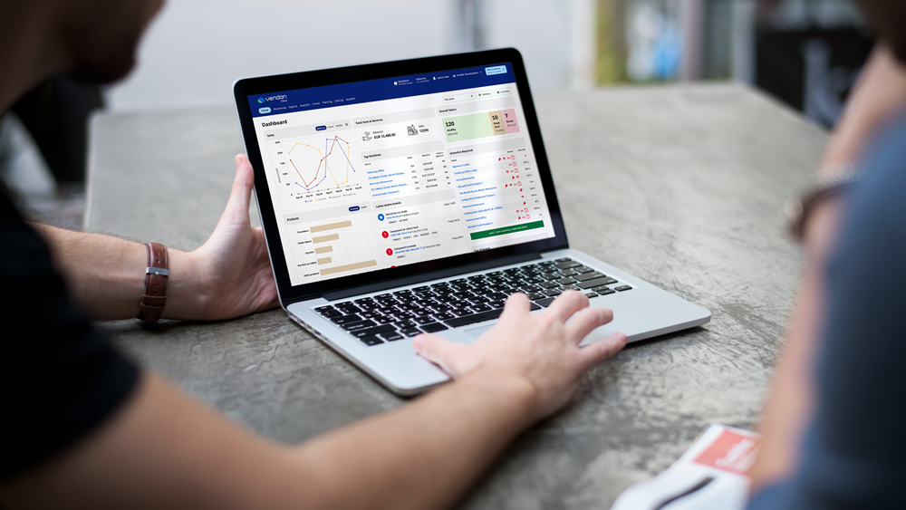 Person arbeitet an einem Laptop mit einem Dashboard für Verkaufsautomaten-Analysen.