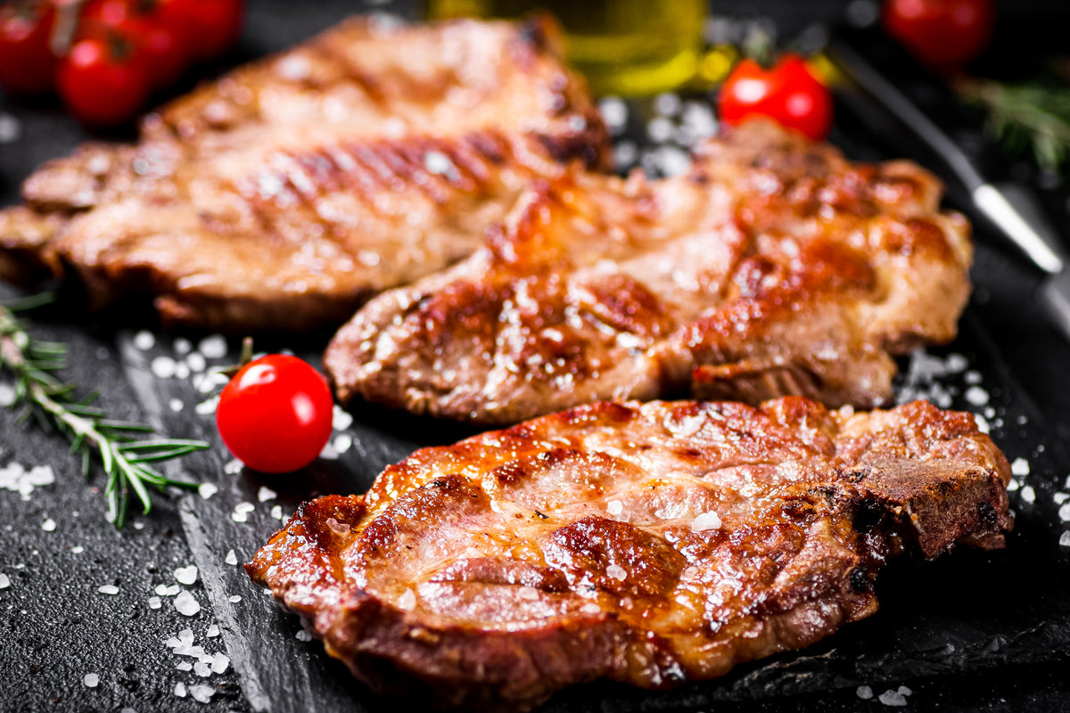 Gegrilltes Steak mit Rosmarin und Kirschtomaten auf Steinplatte